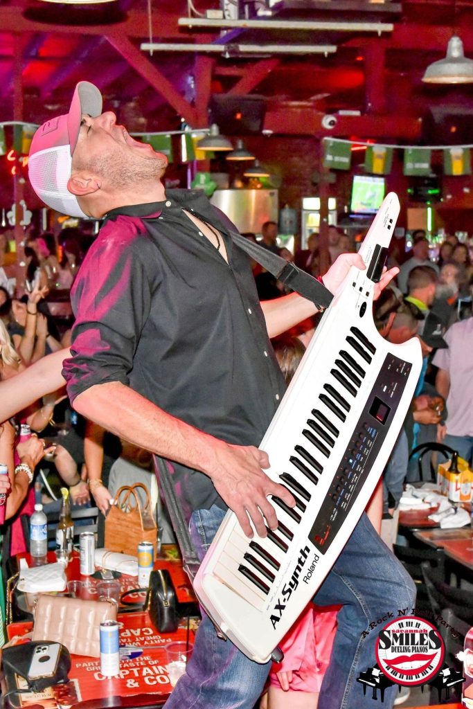 Savannah Smiles entertainer rocking a keytar on stage Savannah Smiles entertainer rocking a keytar on stage